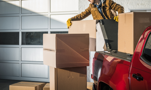 Cardboard boxes being stacked into the back of a pickup truck